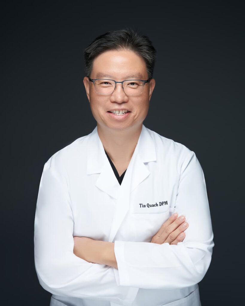 Dr. Tin Quach DPM smiling in white lab coat