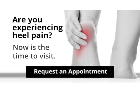 Person clutching painful heel with red inflammation highlighted
