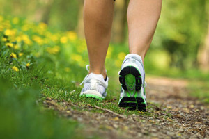 Person walking on a nature trail in white sneakers
