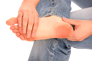 Person holding foot in pain with both hands