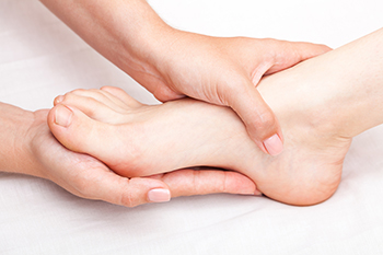 Hands performing a relaxing foot massage therapy