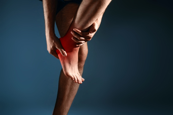 Person holding painful knee with red inflammation highlight