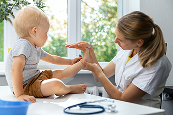 Pediatrician examining a happy toddler during checkup