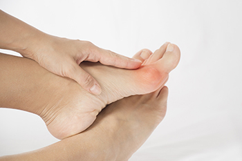 Person holding foot with highlighted pain area near heel